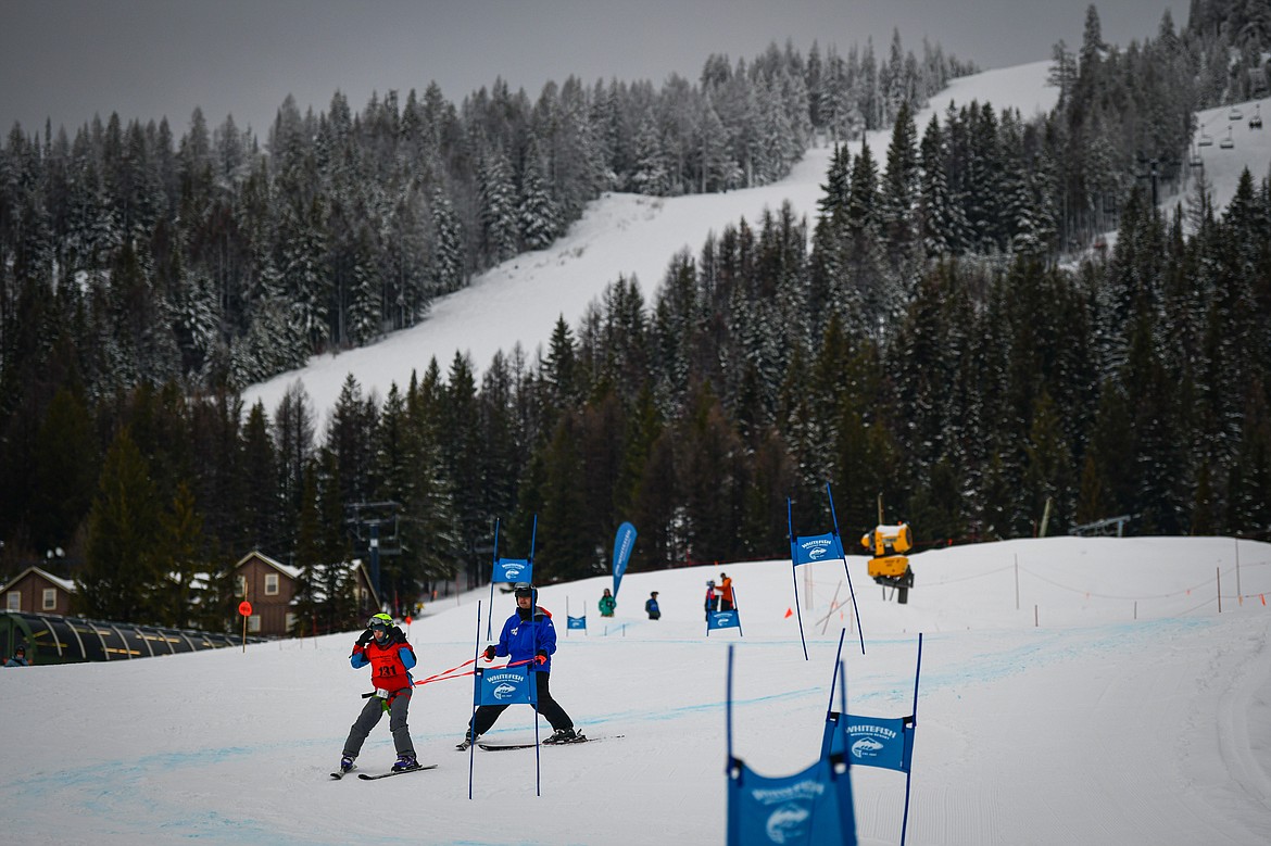 Cole Garvey, with the Eureka Magic team, weaves between gates with Dream Adaptive coach Adrian Miller in the Alpine Slalom event during the Special Olympics Montana Glacier Area Winter Games at Whitefish Mountain Resort on Thursday, Feb. 29. (Casey Kreider/Daily Inter Lake)