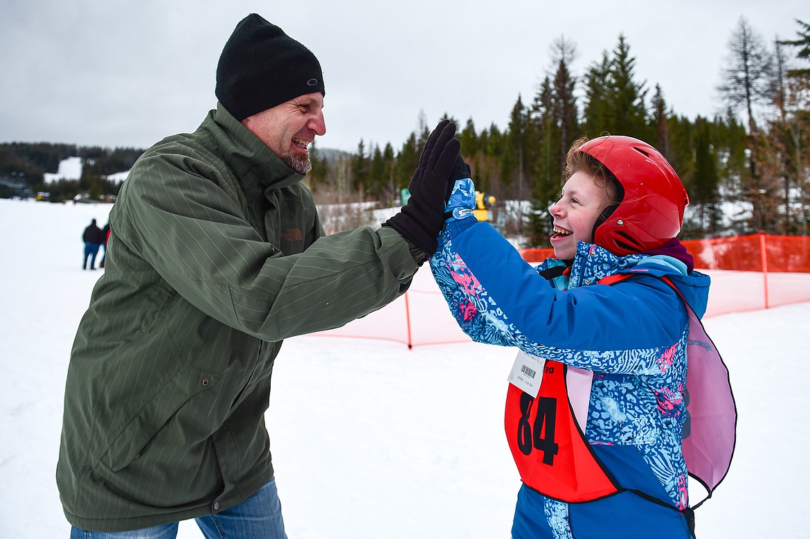 Alivia Westphal, with the Kalispell Public Schools team, gets a pair of high-fives from her father Aaron after her run in the Alpine Slalom event during the Special Olympics Montana Glacier Area Winter Games at Whitefish Mountain Resort on Thursday, Feb. 29. (Casey Kreider/Daily Inter Lake)