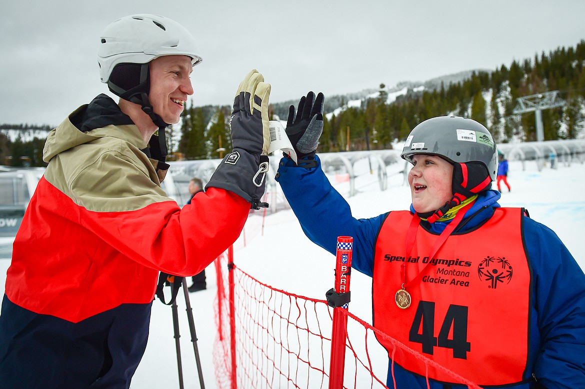 Chase Helzer, right, with the West Valley Warriors team, gets a high five from West Valley teacher and volunteer Joel Ahles after his run in the Alpine Glide event during the Special Olympics Montana Glacier Area Winter Games at Whitefish Mountain Resort on Thursday, Feb. 29. (Casey Kreider/Daily Inter Lake)