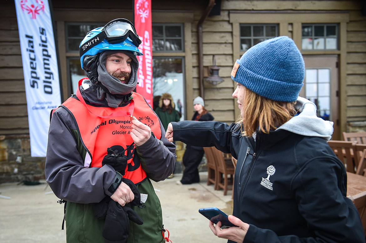 Brian Hayes, left, with the Flathead Industries team, gets a fist bump from Denise Penner, support staff with Flathead Industries, after Hayes received a gold medal in the Alpine Slalom event during the Special Olympics Montana Glacier Area Winter Games at Whitefish Mountain Resort on Thursday, Feb. 29. (Casey Kreider/Daily Inter Lake)