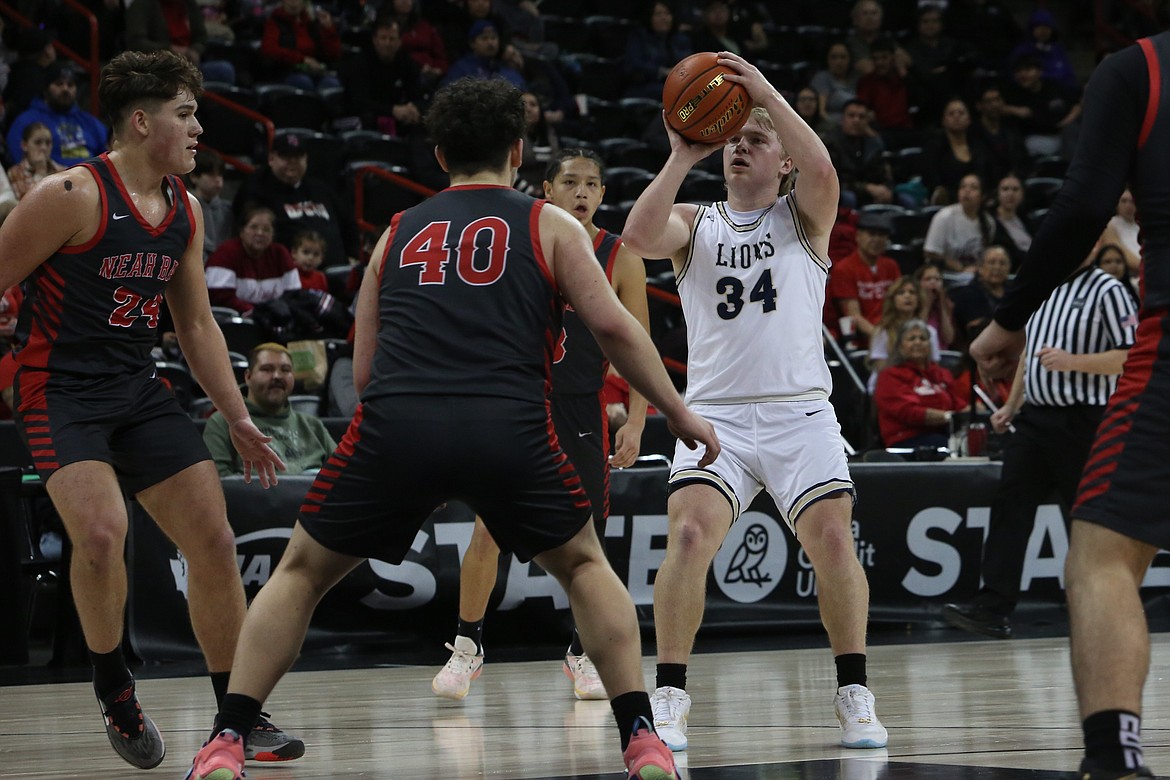 MLCA/CCS senior Jonah Robertson, in white, led the Lions with 18 points against Neah Bay Thursday.