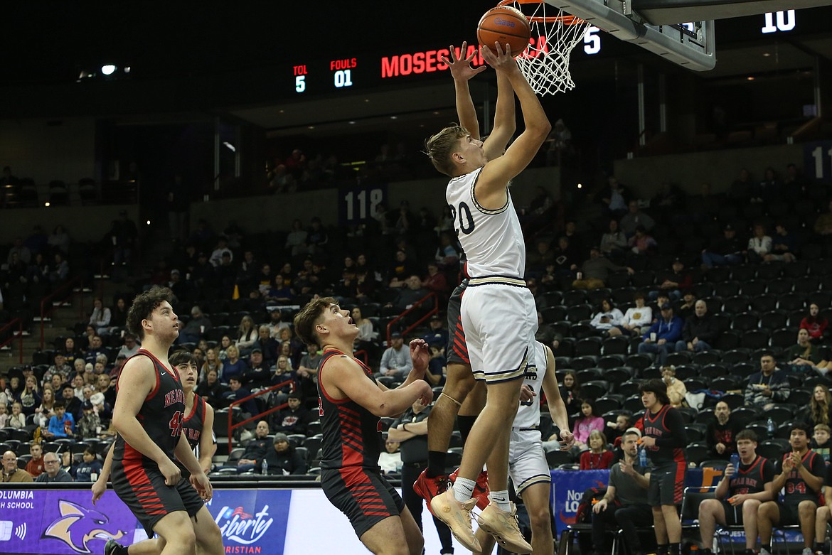 MLCA/CCS freshman Max Gulenko, in white, leaps up for a lay-up in the first quarter.