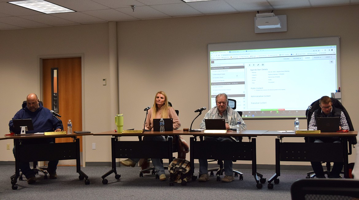 Othello School Board members, from left to right, Isauro Pruneda, Lindsy Mollotte Prows, Kenneth Johnson and Chris Baginski look over the agenda prior to Monday’s regular meeting.