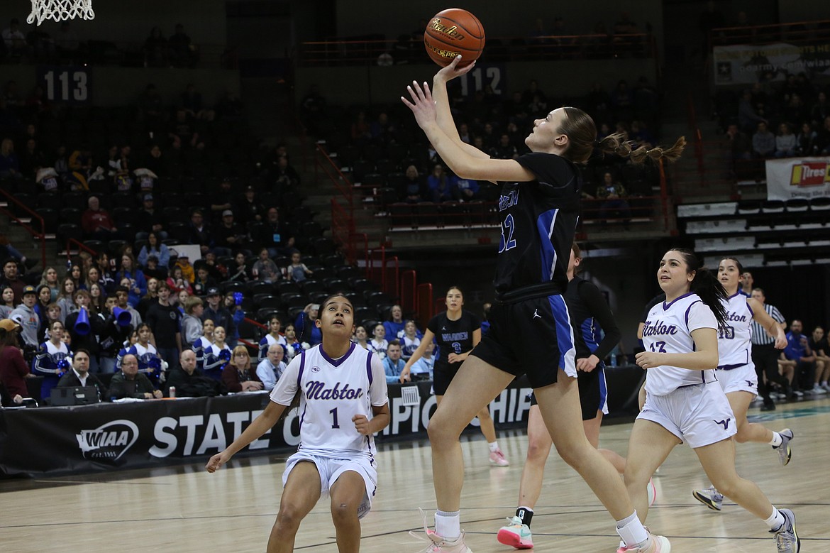 Warden junior Lauren Chamberlain, in black, lays the ball in for a basket in the first quarter against Mabton.