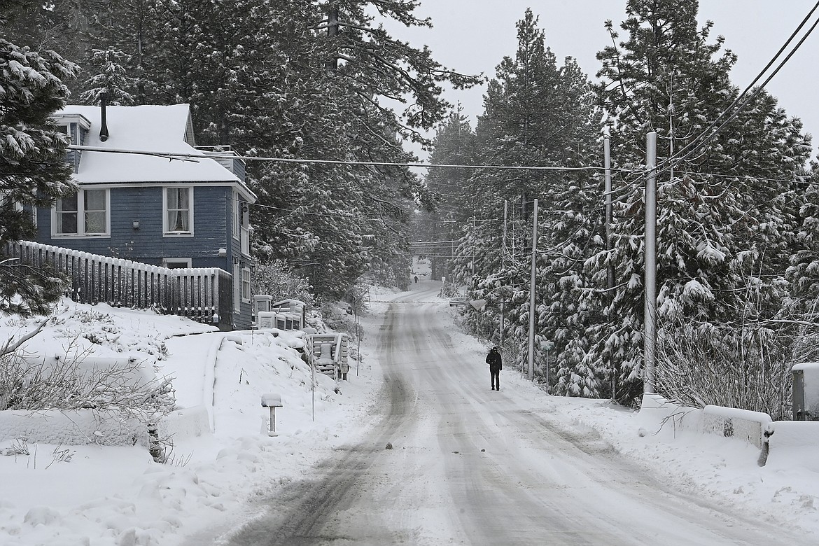 A person walks along a covered Jibboom Street on Friday, March 1, 2024, in Truckee, Calif. The most powerful Pacific storm of the season is forecast to bring up to 10 feet of snow into the Sierra Nevada by the weekend (AP Photo/Andy Barron)