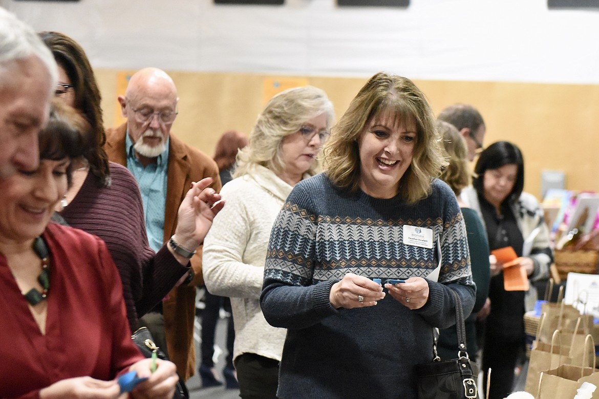 Heather Howlett browses raffle items at the Bigfork Chamber of Commerce banquet and awards ceremony in Bigfork on Thursday, Feb. 22, 2024. (Matt Baldwin/Daily Inter Lake)