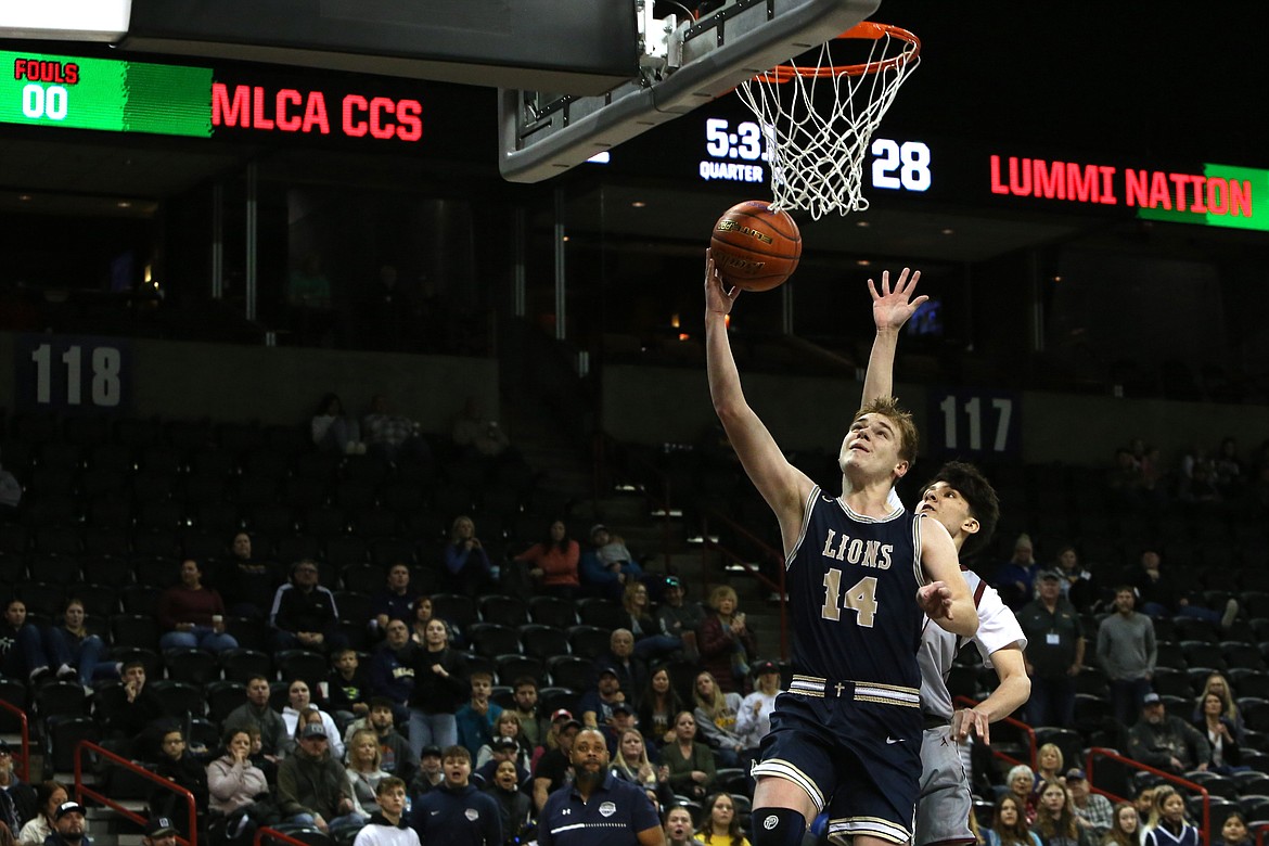 MLCA/CCS sophomore James Robertson (14) lays the ball in for basket in the second half against Lummi Nation.