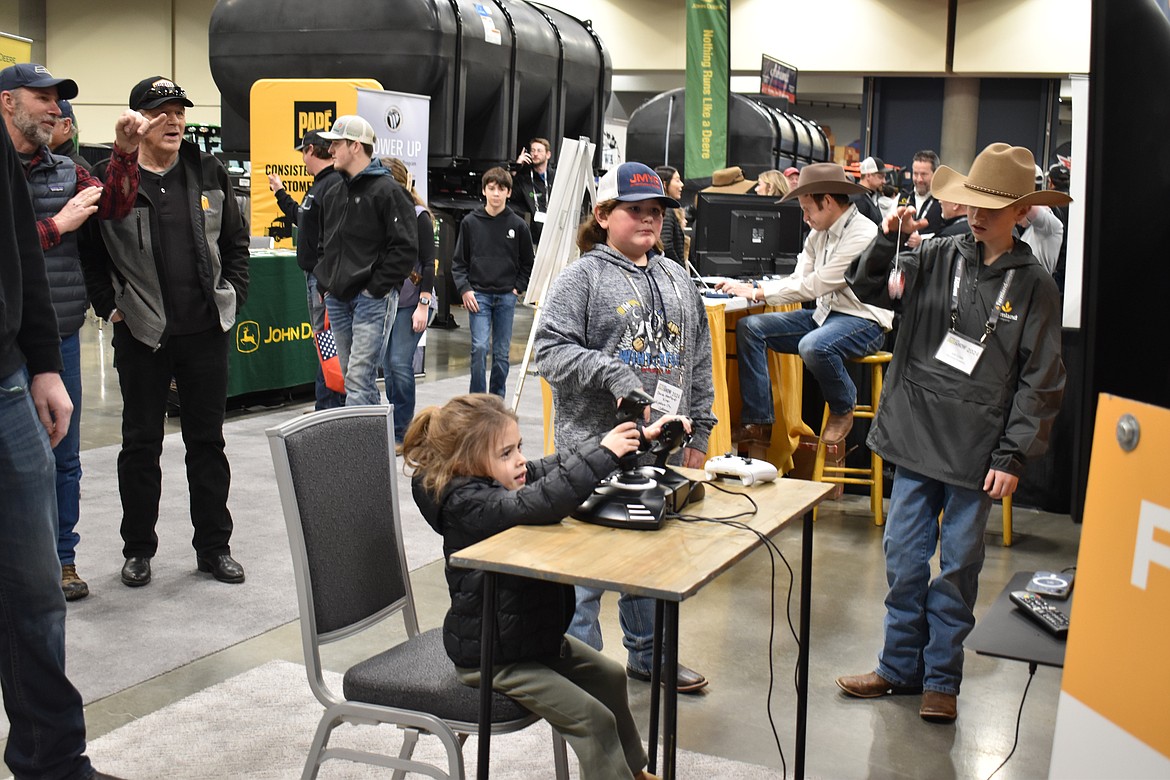 Kamryn Schroeder, 4, from Wilbur, Washington attempts to land a crop duster in a video game-style simulator at the Spokane Ag Show Feb. 7.