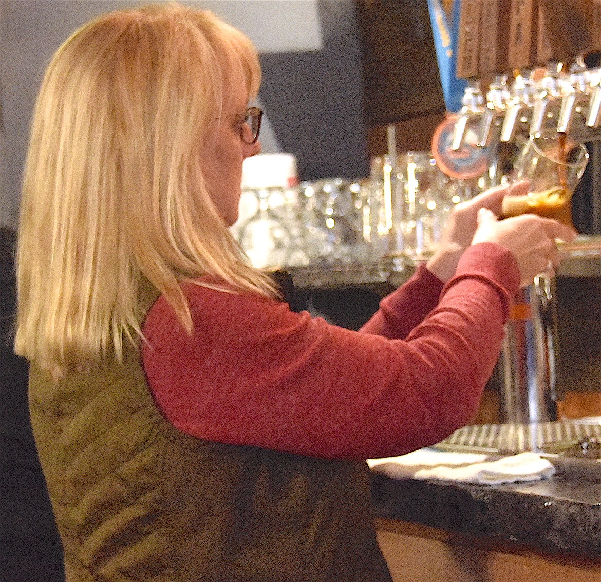 Heather Gray pulls a brew on a busy Friday night at the Ronan Cooperative Brewery. (Berl Tiskus/Leader)