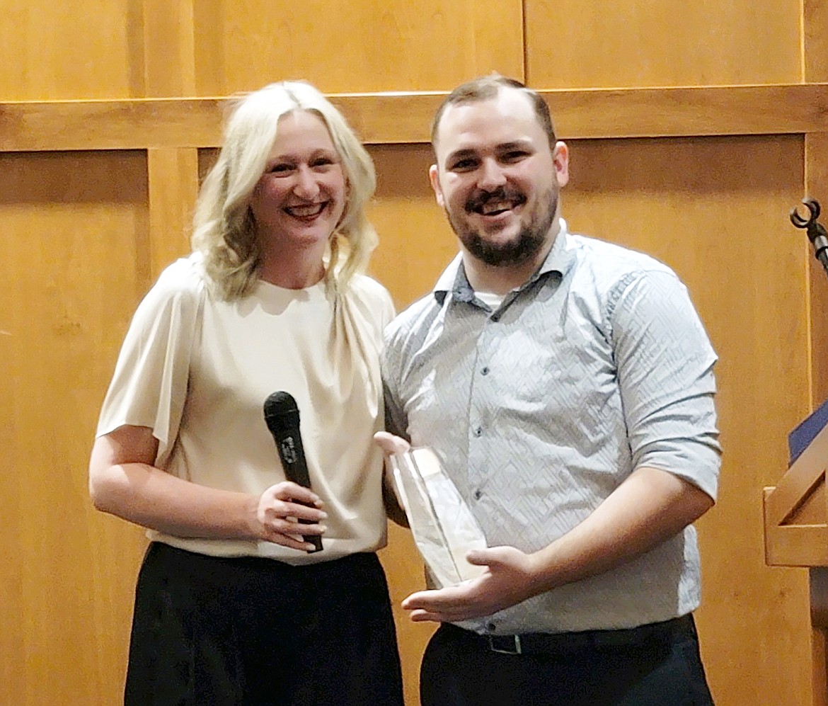 Newport Hospital and Health Services CEO Merry-Ann Keane, left, presents Josh Midkirk with the 2024 Iron Sommelier award.