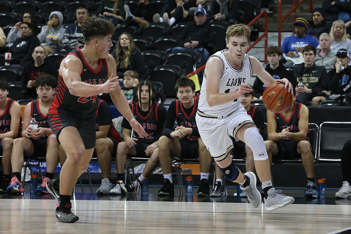 MLCA/CCS sophomore James Robertson (14) keeps his eye on the baseline while dribbling the ball against Neah Bay at the 1B Boys State Basketball Tournament in Spokane.