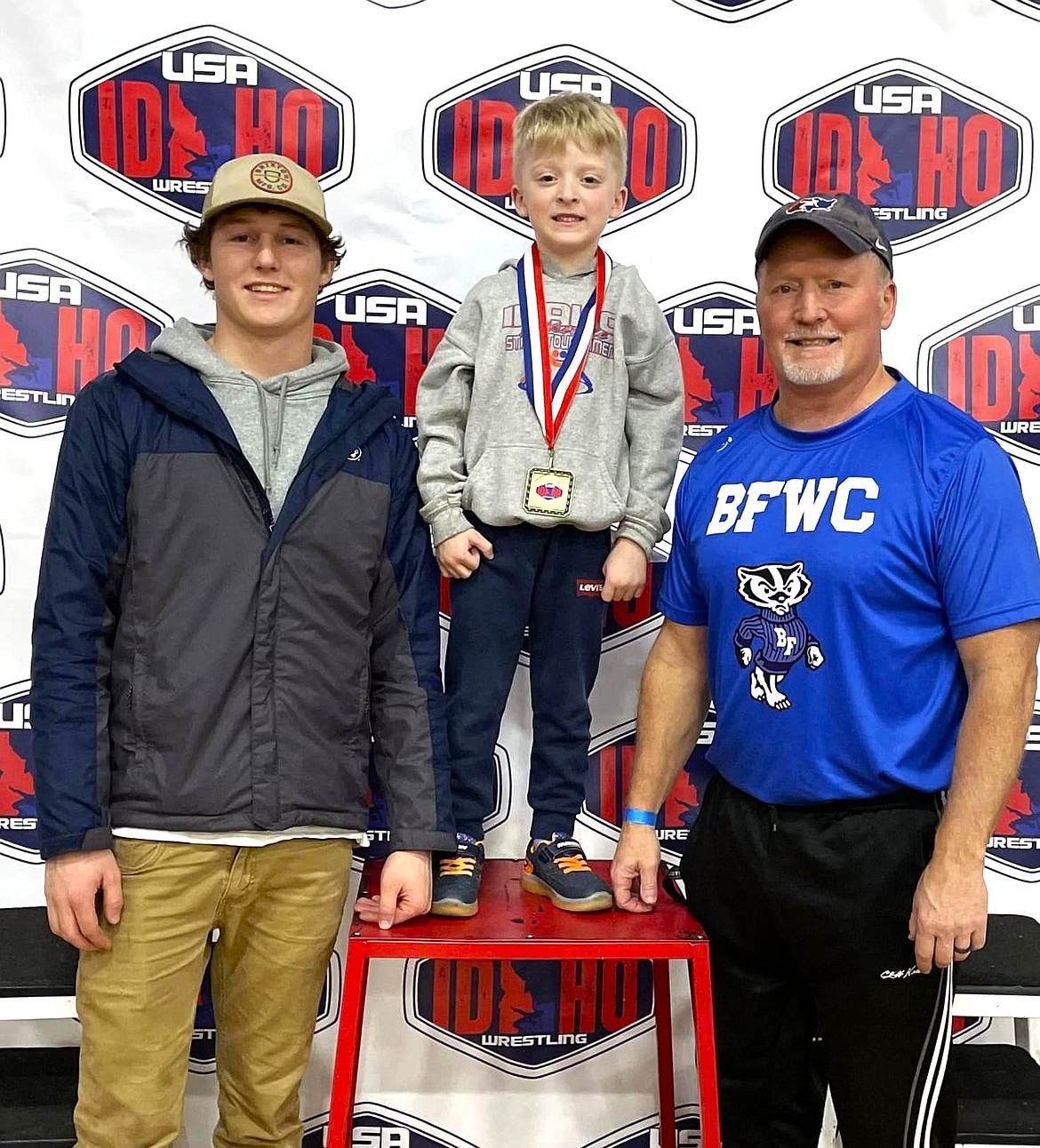 (center) Titan Richards pre-k-kindergarten, took fourth place, at Idaho State Folkstyle Championships and poses with his brother, (left) Eli Richards and father, (right) Corey Richards.