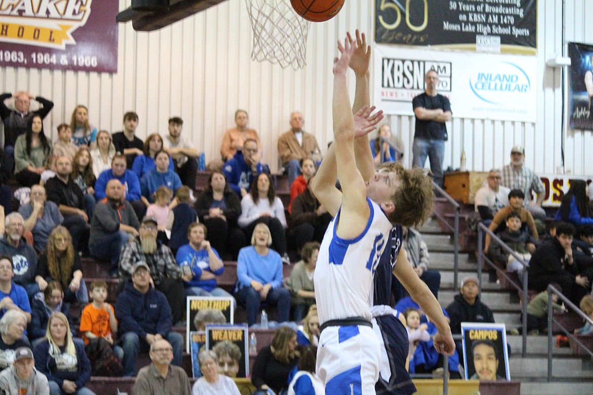 Soap Lake senior Andrey Sushik, in white, lays the ball up toward the rim in the 1B Boys State Basketball regional round against Summit Classical Christian.