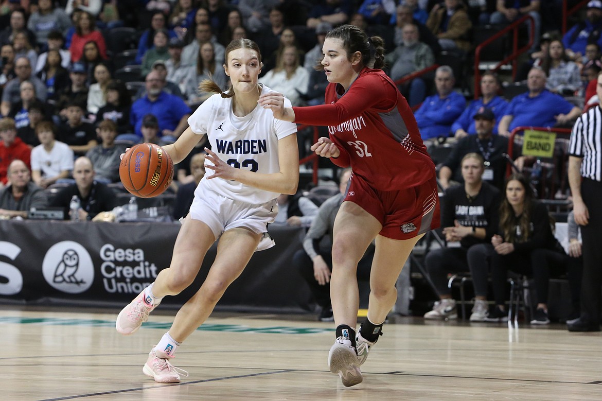 Warden junior Lauren Chamberlain, in white, dribbles the ball into the paint against Okanogan in the 2B Girls State Basketball Tournament semifinals.