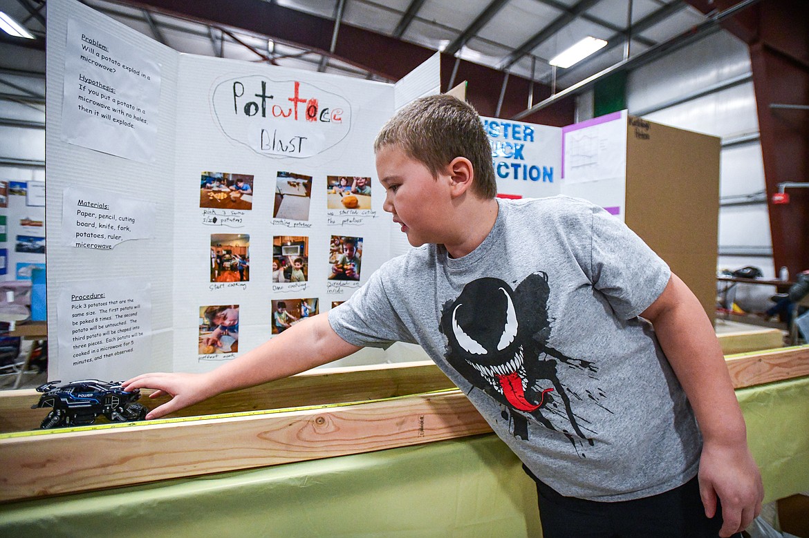 Edgerton Elementary third-grader Brody Hall demonstrates his project "Monster Truck vs. Friction" which sought to determine the amount of friction produced by different materials when running his toy monster truck over them, to judges at the Flathead County Science Fair at the Flathead County Fairgrounds Expo Building on Thursday, March 7. (Casey Kreider/Daily Inter Lake)