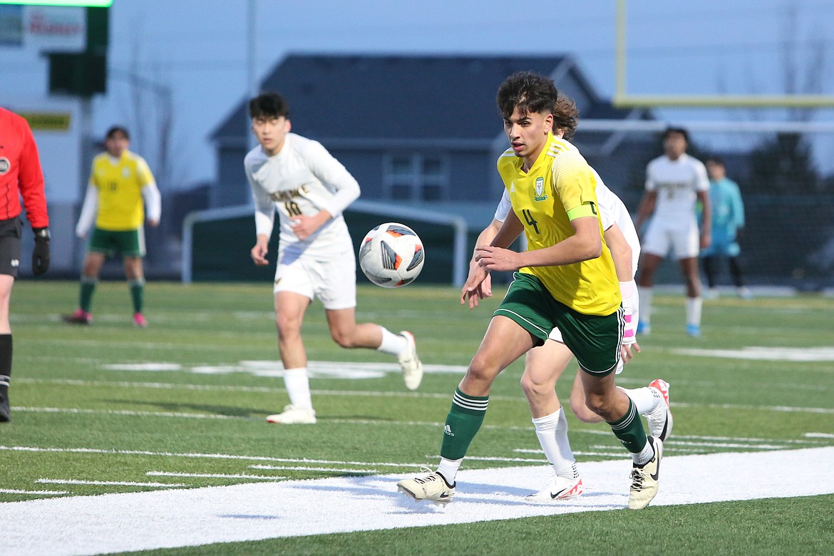 Quincy senior Guillermo Gomez (4) brings the ball up the field against Overlake Friday night. Gomez scored a game-tying goal in second-half stoppage time, with the match later ending in a 1-1 draw.