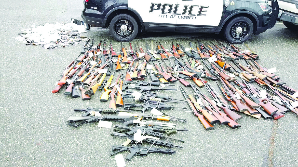 Returned lost or stolen firearms recovered by the Everett Police Department are laid out in a parking lot. The department started a program to get guns off the street called “guns for gift cards.”