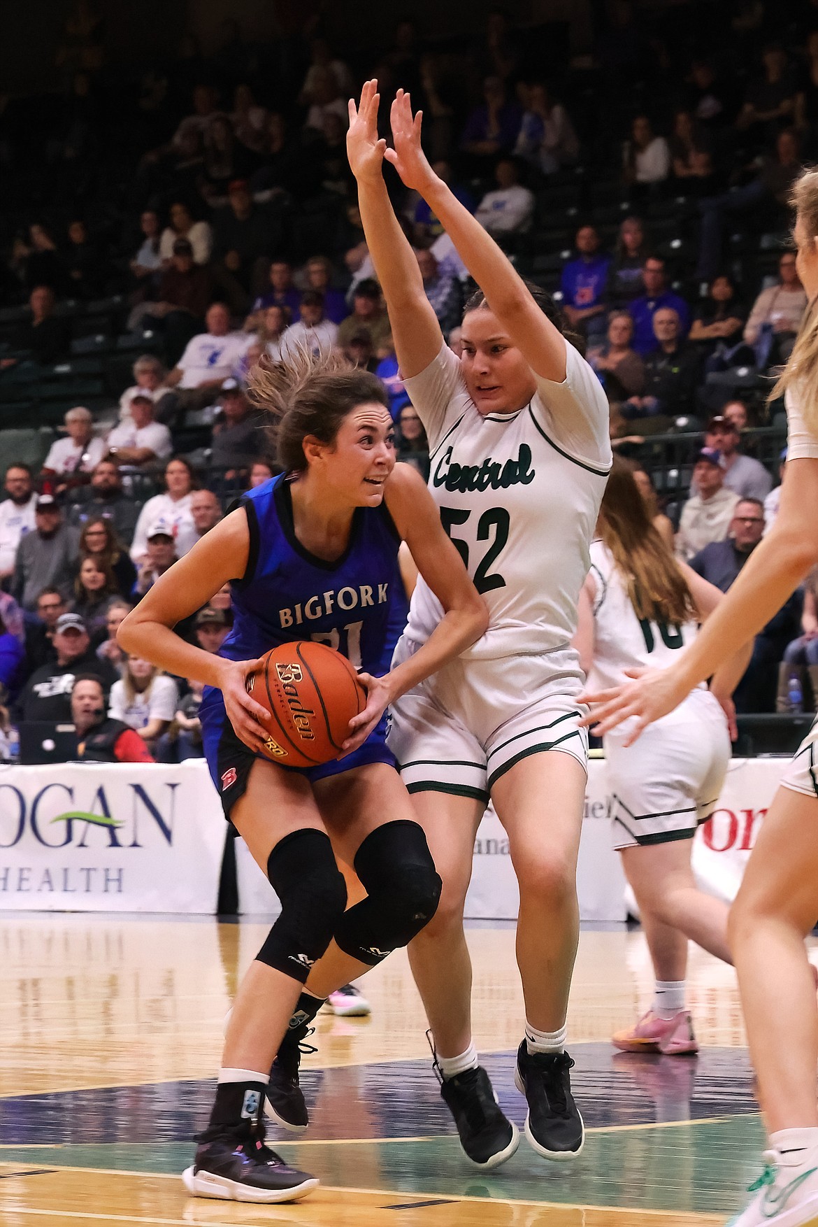 BIGFORK’S BRAEDEN GUNLOCK (21) works the ball against Billings Central post player Coral Old Bull (52) during Saturday’s State A girls basketball championship Saturday in Butte. Billings Central won 41-38. (Gregory Nelson/artwestimage.com)