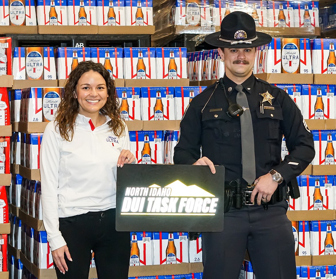 Annie Pfinsgraff with Watkins Distributing stands Monday morning with Idaho State Police Sgt. Austin Rosedale at Watkins Distributing in Hayden. Watkins and the DUI Taskforce formed a partnership to help keep people from drinking and driving over the St. Patrick's Day weekend.