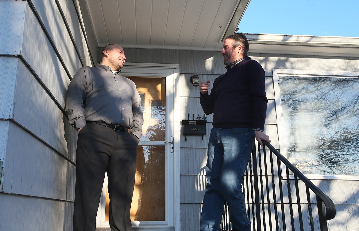 Paul Myers, left, and Geoff Carr chat for a moment on their front porch Wednesday. Carr, a North Idaho College instructor, bought the house in 2013 and is now renting a room to Myers, a 2023 NIC grad and current University of Idaho student, after being connected by a mutual contact when Myers needed emergency housing.
