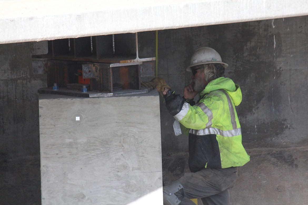 With the temporary supports in place, a construction worker verifies Bridge 202 is sitting properly.