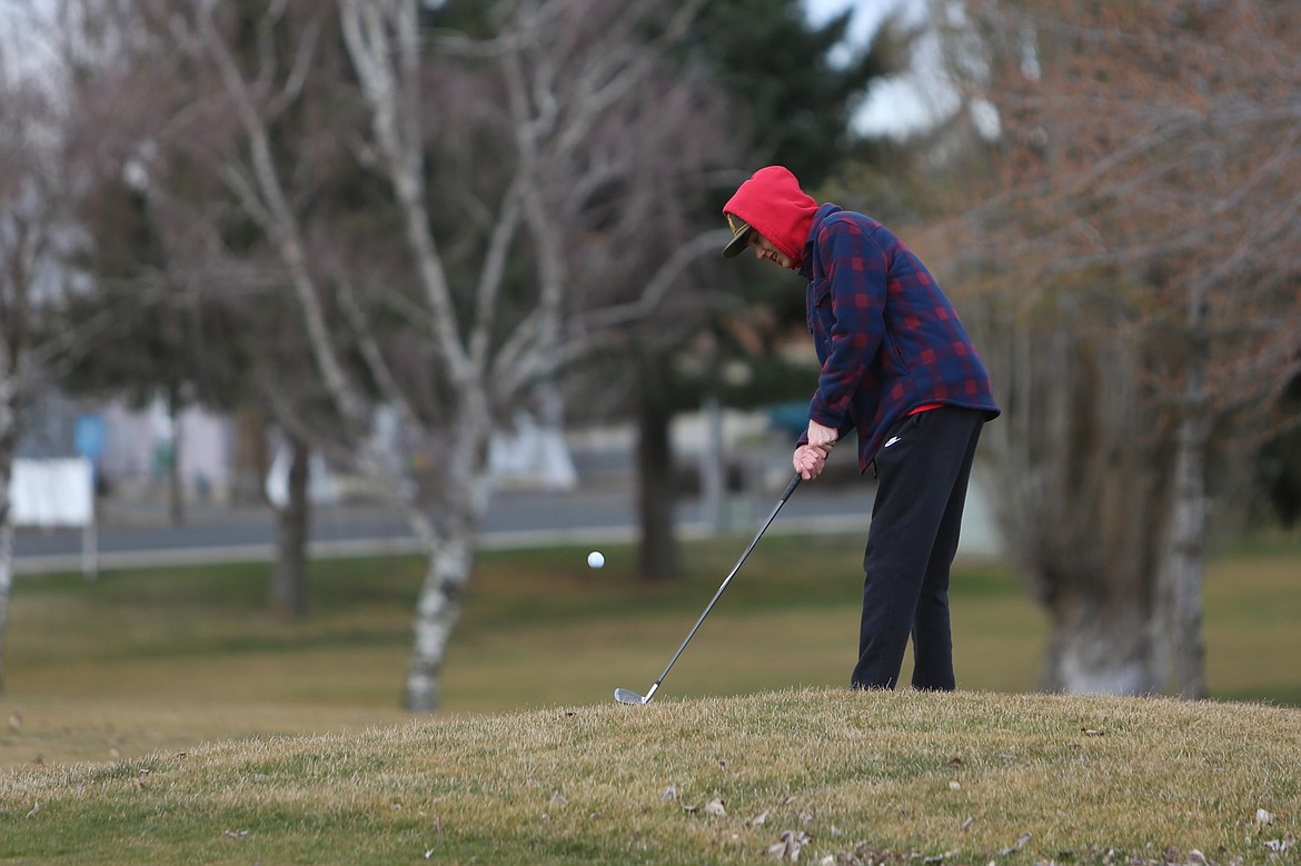 Broncos junior Brix Curtis chips the ball toward the green during a March 12 practice.