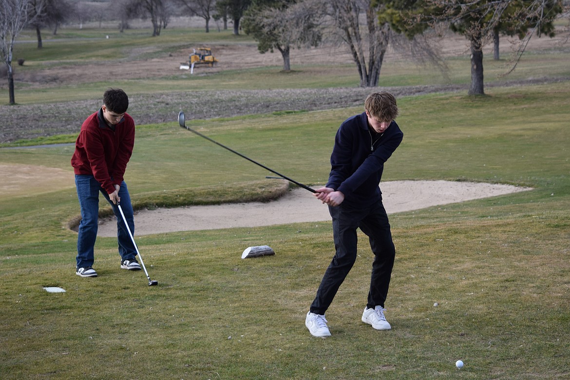 Two Warden Boys Golf players practice their swing during their Friday evening practice at Sage Hills Golf Club.