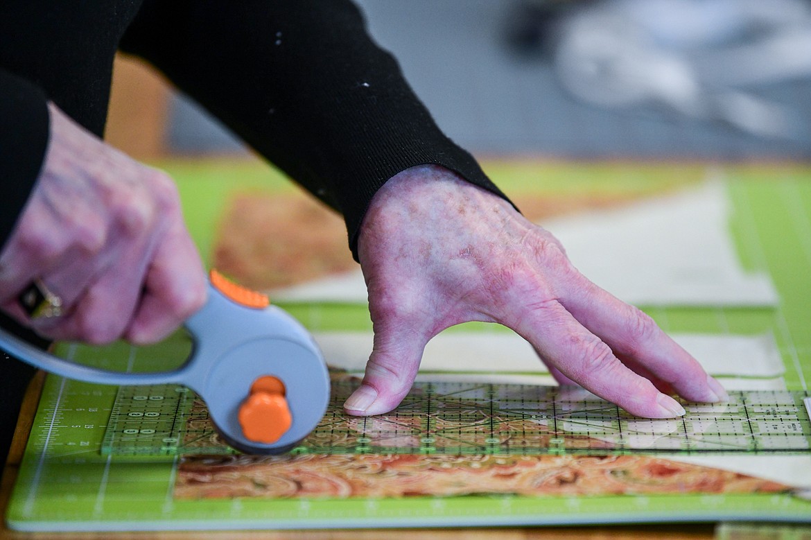 Shelly Withall cuts material to create mountains in a "Delectable Mountains" quilt during a Flathead Quilters' Guild sewing day at the Quilt Gallery in Kalispell on Wednesday, March 13. (Casey Kreider/Daily Inter Lake)