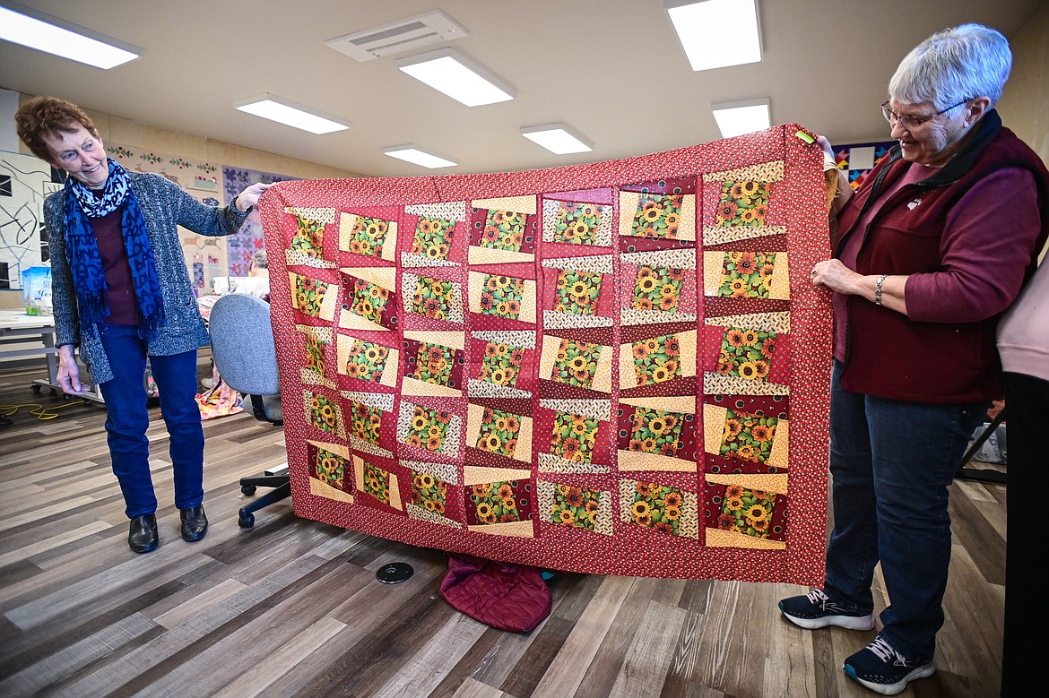 Nancy Dahl and Nancy Richwine, members of the Flathead Quilters' Guild, hold up a quilt titled "Keep It Simply Slanted" during one of the Guild's sewing days at the Quilt Gallery in Kalispell on Wednesday, March 13. (Casey Kreider/Daily Inter Lake)