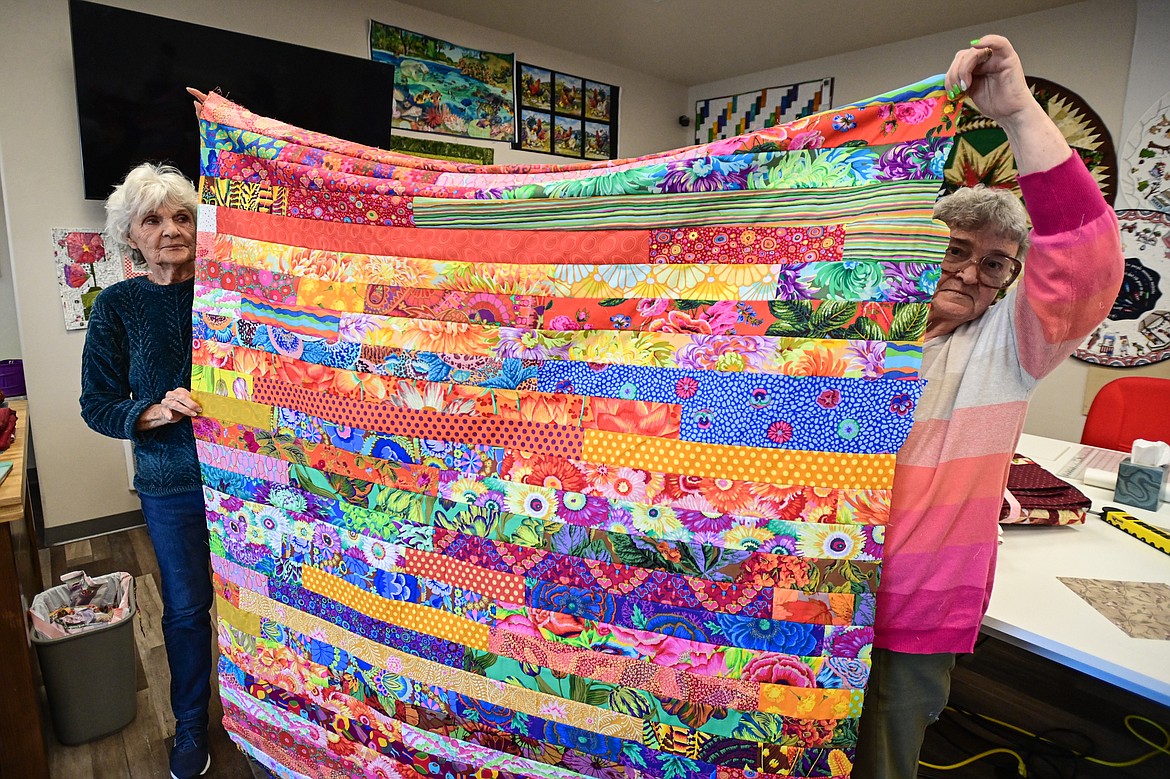 Adelyn Moss and Linda Anderson hold up a quilt titled "Mile A Minute" during a Flathead Quilters' Guild sewing day at the Quilt Gallery in Kalispell on Wednesday, March 13. (Casey Kreider/Daily Inter Lake)