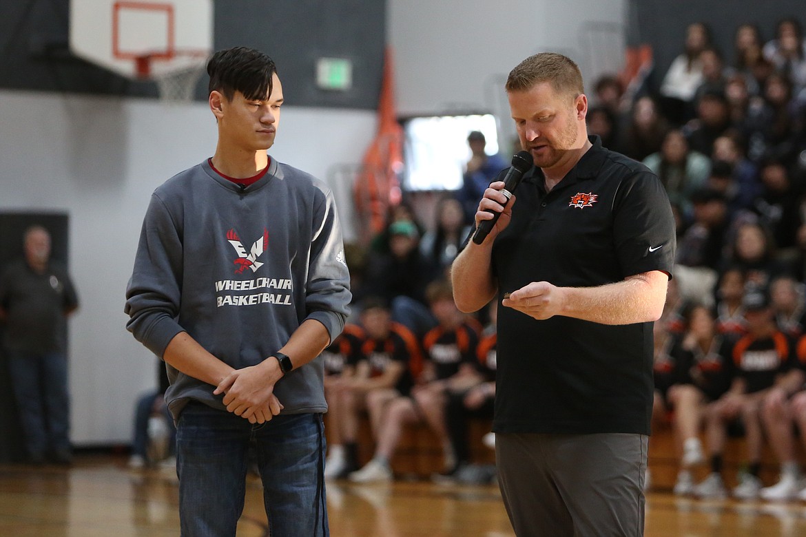 Ephrata High School senior Ben Belino, left, is presented the EHS Challenge Coin by Athletic Director Bryan Johnson during an assembly on Dec. 8. Belino has a prosthetic that allows him to stand, walk and even run, but said he's found he has an affinity for wheelchair racing.