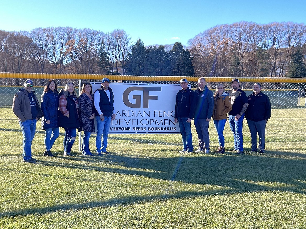 Ephrata community members stand in front of new fencing they helped put in for Ephrata High School at the athletic fields there.