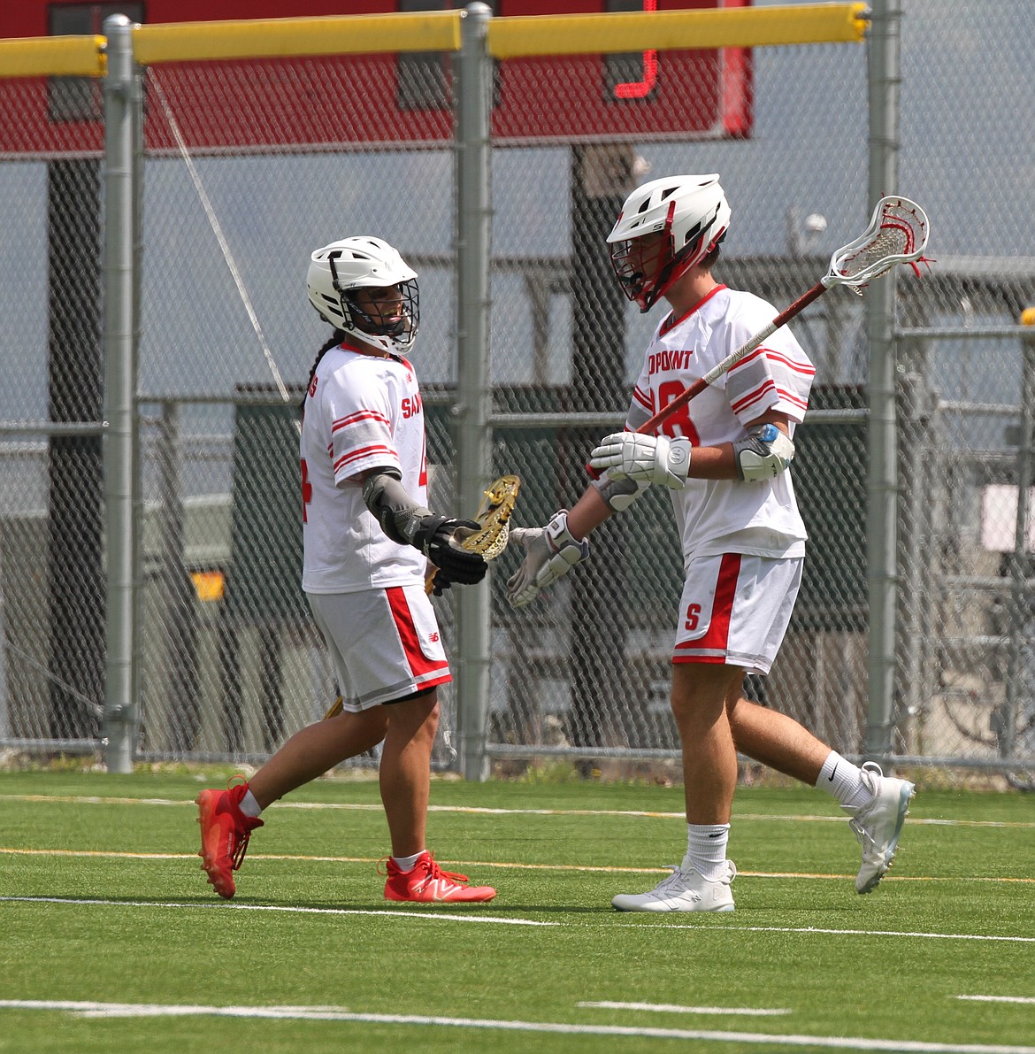 Sandpoint's Blayne Kanning (right) high-fives former Bulldog Levi Balison after scoring a goal in a game held at War Memorial Field last season.