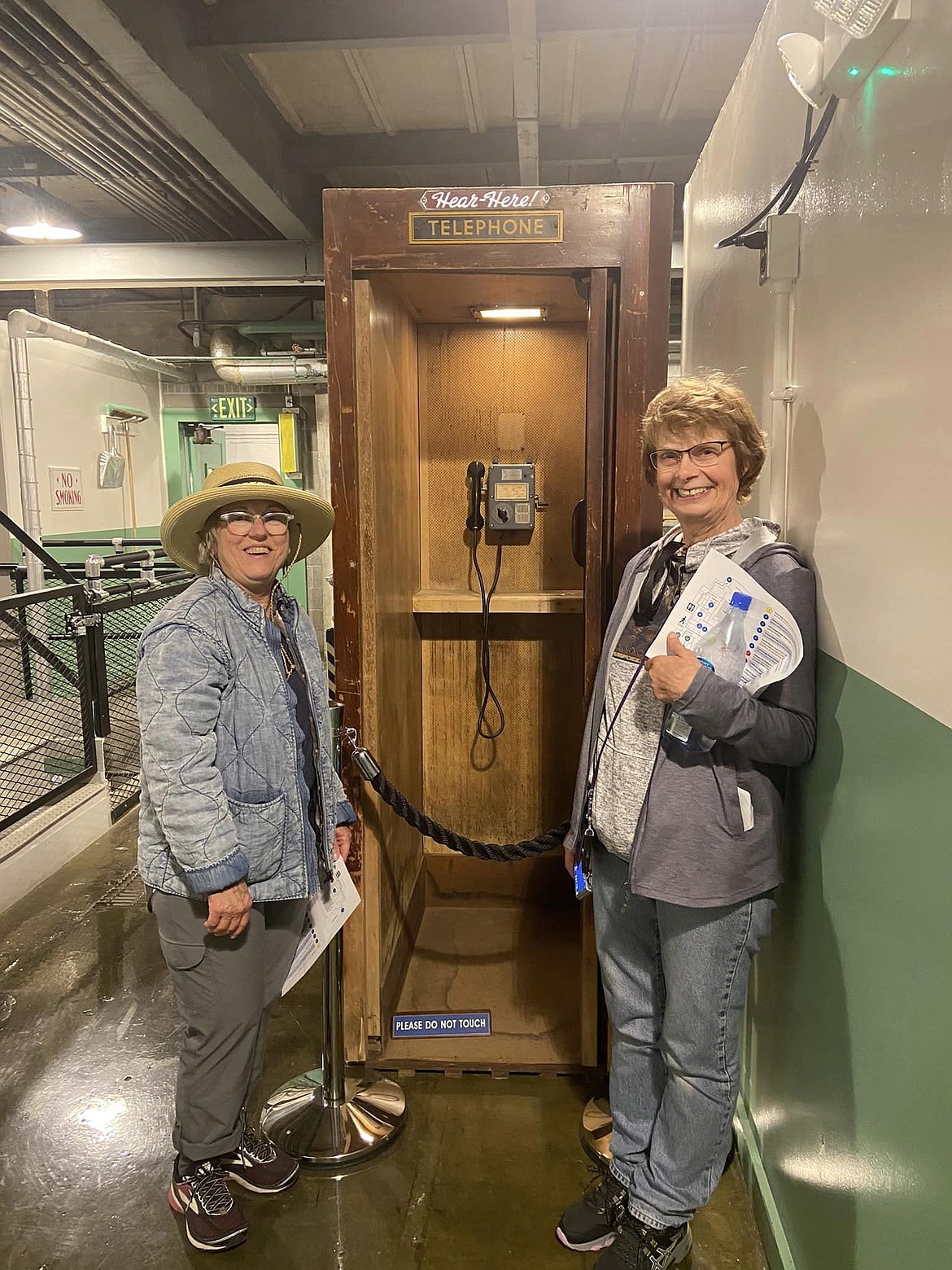 Quincy museum participants pose with an ancient artifact, a 1940s telephone, during a tour of the Hanford nuclear site in 2023.