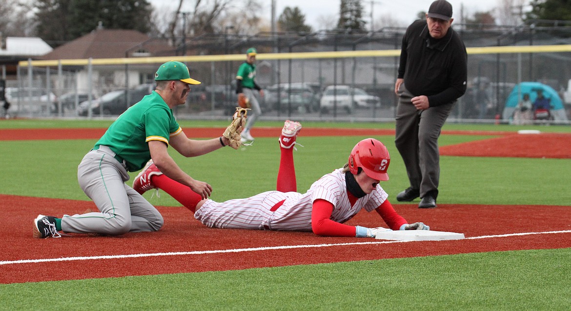 Sandpoint's Finn Mellander slides into third base for a triple in a game last season against Lakeland at War Memorial Field.