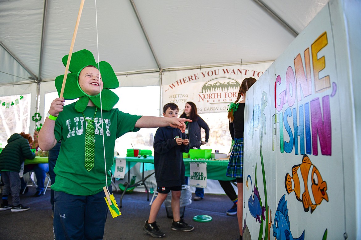 Noah Kent reels in a prize at a fishing game in the kids carnival area at Cloverfest in Columbia Falls on Saturday, March 16. (Casey Kreider/Daily Inter Lake)
