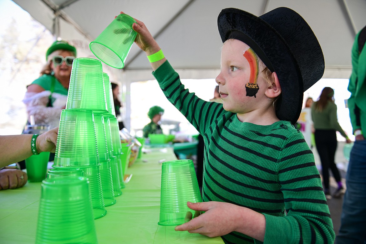 Malcolm Craig plays a cup stacking game in the kids carnival area at Cloverfest in Columbia Falls on Saturday, March 16. (Casey Kreider/Daily Inter Lake)
