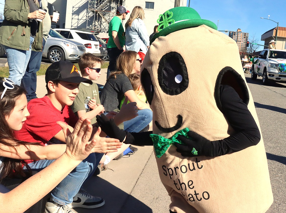 Lincoln Dietz sports a spud outfit as he gives out high fives in the St. Patrick's Day Parade on Saturday.