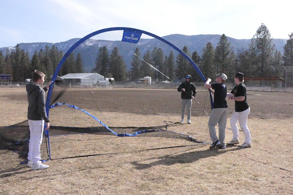 Players assemble the portable batting cage prior to a practice this past week in Thompson Falls. (Chuck Bandel/VP-MI)