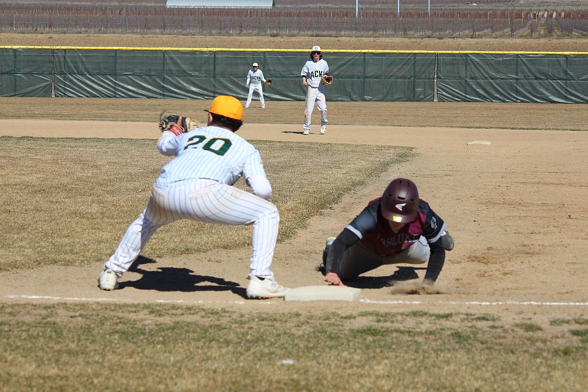 A Wahluke runner dives back to first in Saturday’s road game against Quincy.