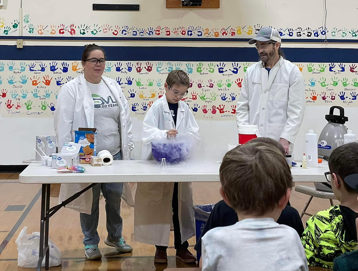 Kale Swainston and Heather LaPierre from Silver Valley Analytical Labs with student Vito Waldo during a recent Science Friday event where the students learned about chemical reactions with regard to phase changes and oxidation.