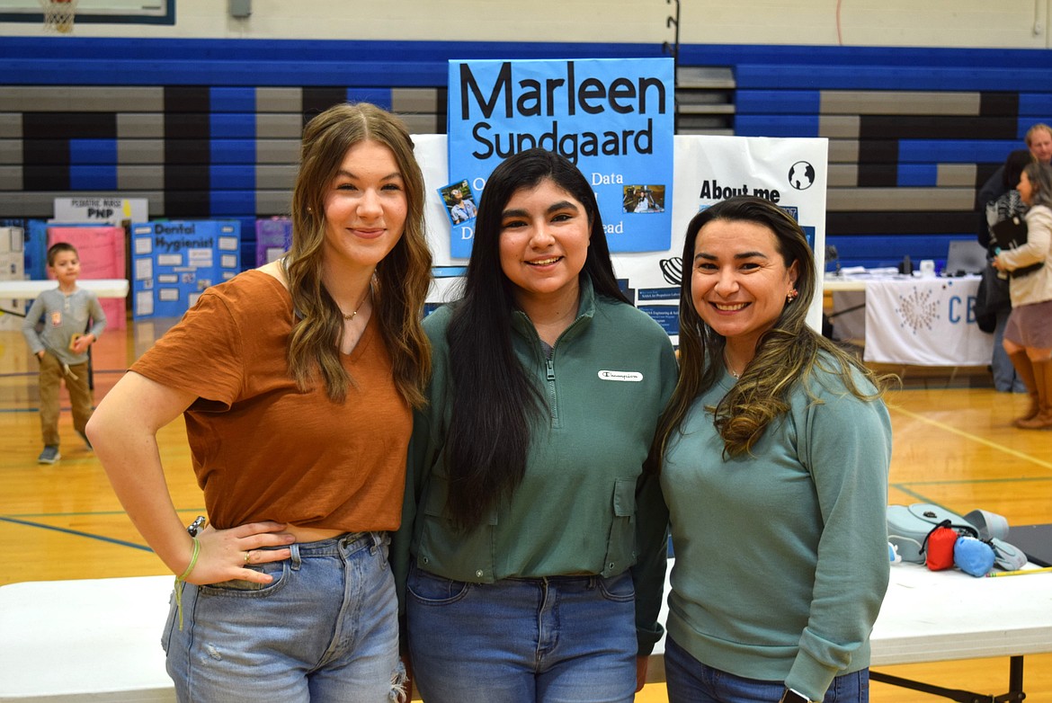 Warden students Haley Sicklovan, Kaylie Vela and NASA Jet Propulsion Laboratory Engineer Marleen Martinez Sundgaard – also a Warden graduate – stand in front of Sundgaard’s display board for the networking portion of Thursday evening’s Warden Post-Secondary Science, Technology, Engineering and Mathematics Day.