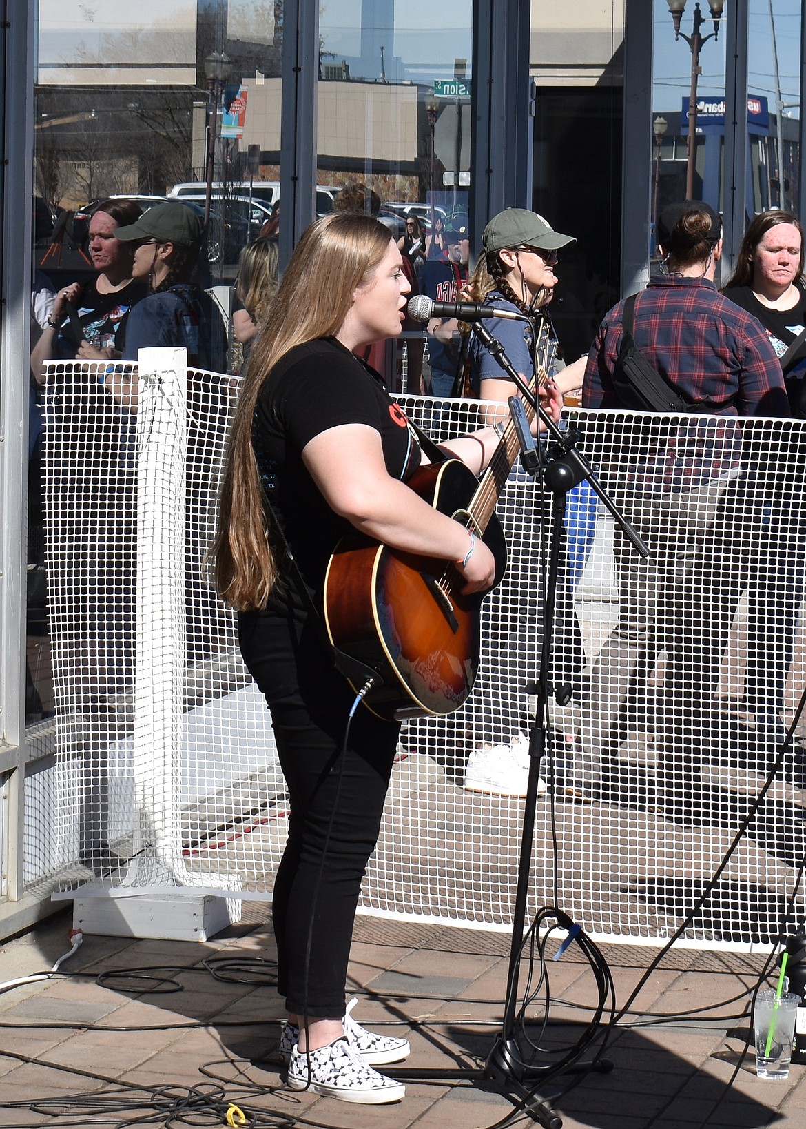 Whitley Rushton sings outside Windermere Real Estate in Moses Lake. Rushton was one of 12 musical acts performing at downtown businesses at Brews and Tunes Saturday.