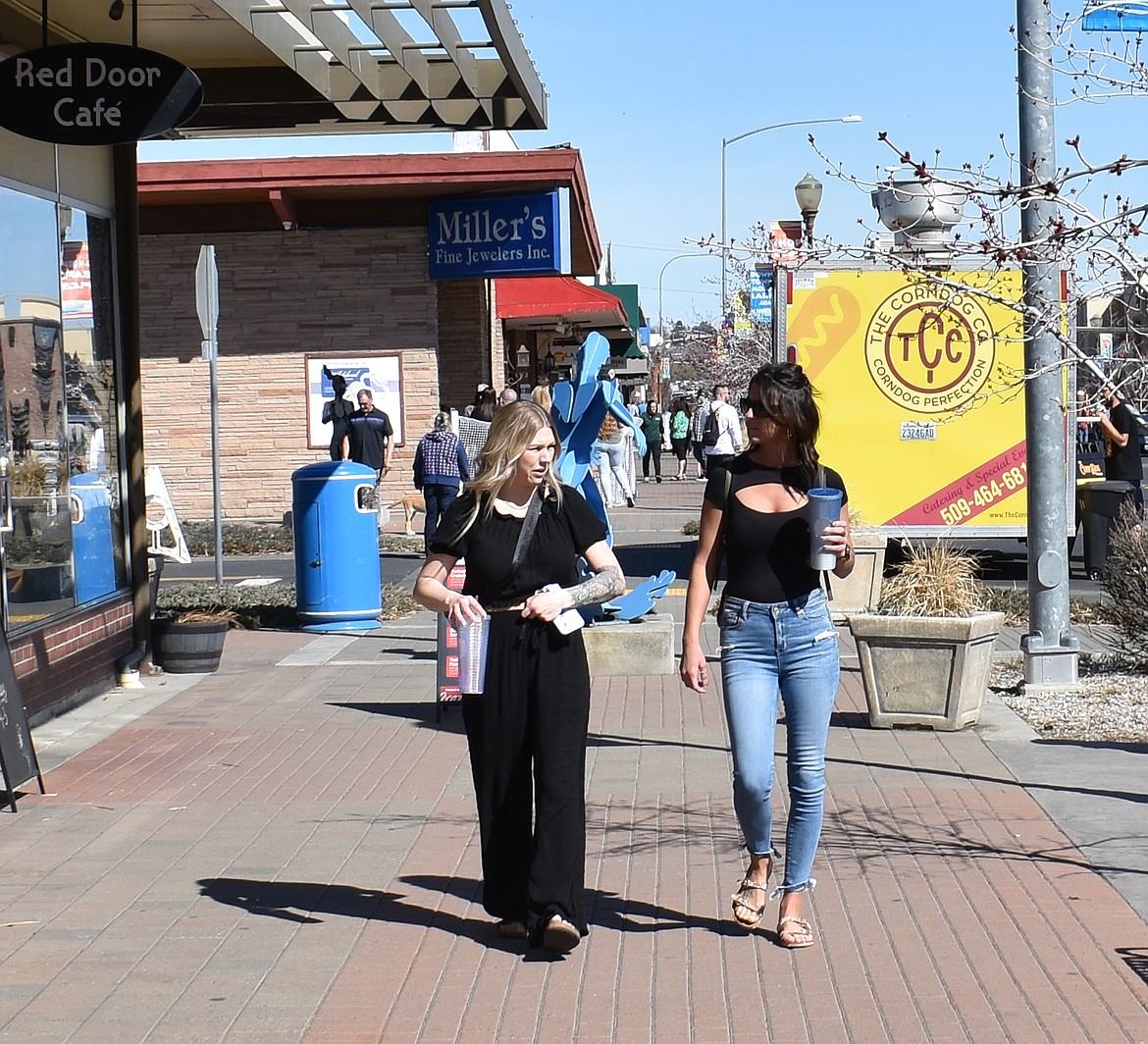 Macaela Hayes, left, and Kamren Hicks enjoy the sunshine downtown at Brews and Tunes Saturday. They weren’t able to get tickets for the beer tasting, they said, but they stayed for the shopping anyway.