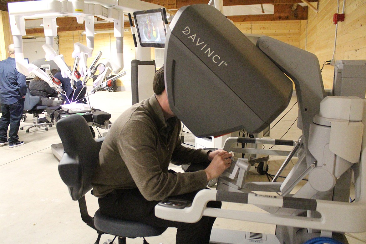 Kyrk Taylor manipulates the da Vinci medical robot, background, during a demonstration Monday.