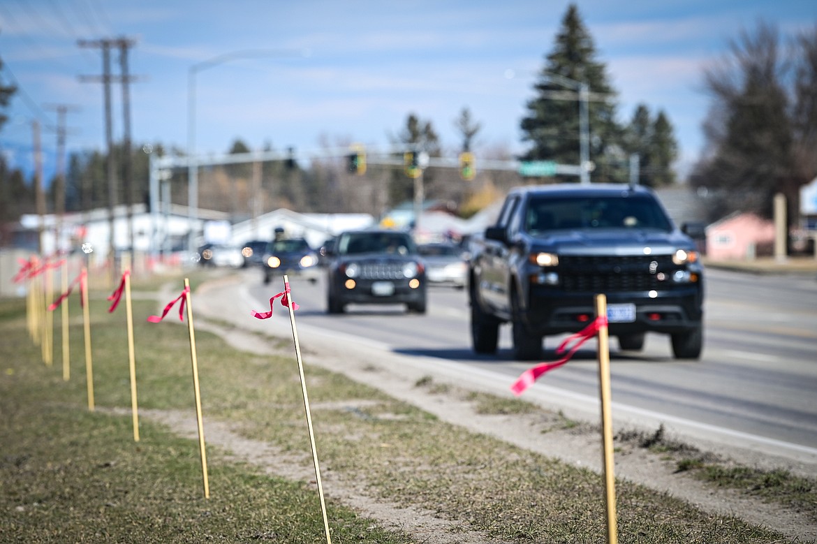 Stakes with red ribbons  along the path of the soon-to-be-installed sidewalk along U.S. Highway 2 in Evergreen on Wednesday, March 20. (Casey Kreider/Daily Inter Lake)