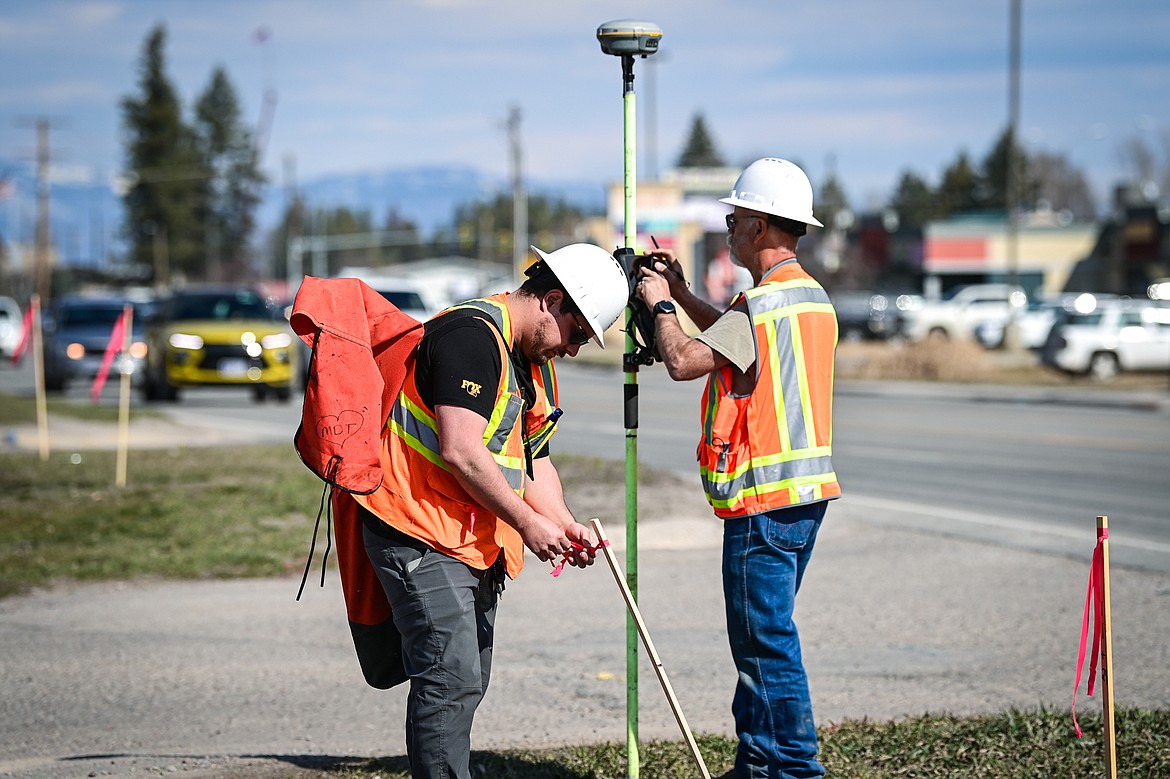 A survey crew from the Montana Department of Transportation places stakes with red ribbons along the path of the soon-to-be-installed sidewalk along U.S. Highway 2 in Evergreen on Wednesday, March 20. (Casey Kreider/Daily Inter Lake)