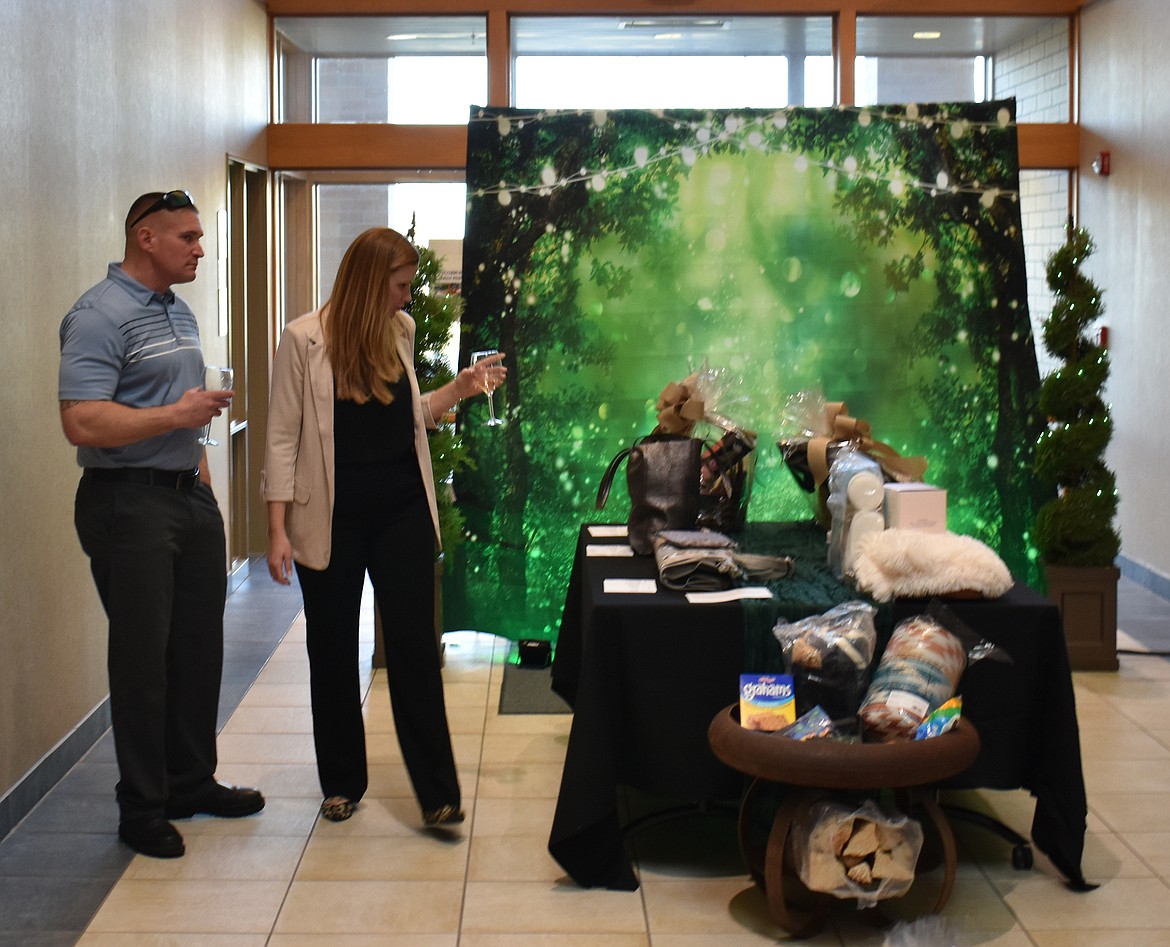 Brian, left, and Rebecca Johnson of Moses Lake look over silent auction items at Cellarbration! Saturday.