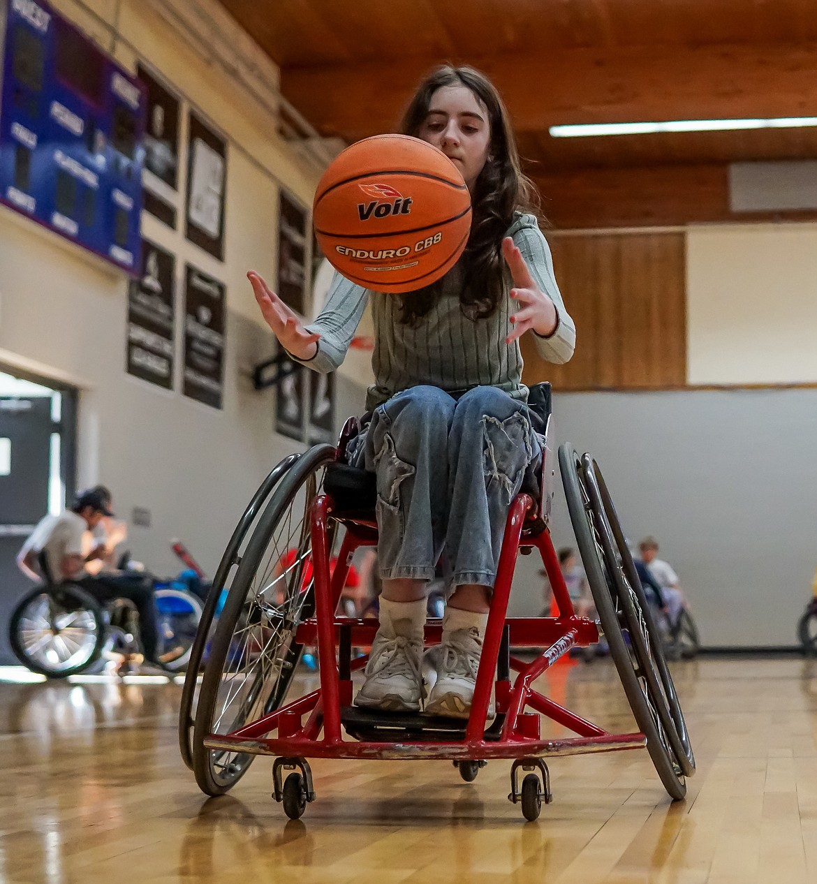 Charlotte Cook practices dribbling a basketball while in a wheelchair at Lake City Academy Tuesday afternoon.