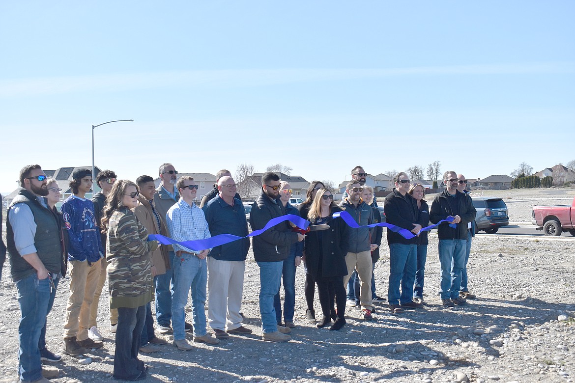 Hayden Homes Project Manager Aziel Barraza, flanked by Hayden Homes representatives and members of the Moses Lake community, cuts the ribbon at the Polo Ridge development on Paxson Drive.